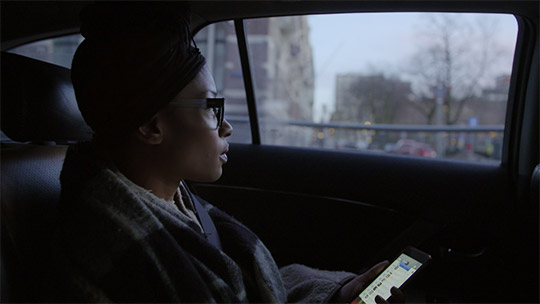 Sylvana Simon sitting in a car looking through a window. It has a touch of lonliness.