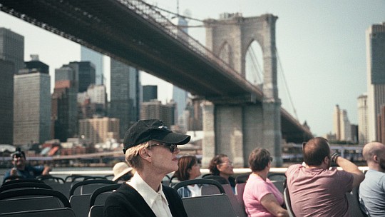 Siri Hustvedt am Deck eines Boots im Hintergrund eine Brücke in New York